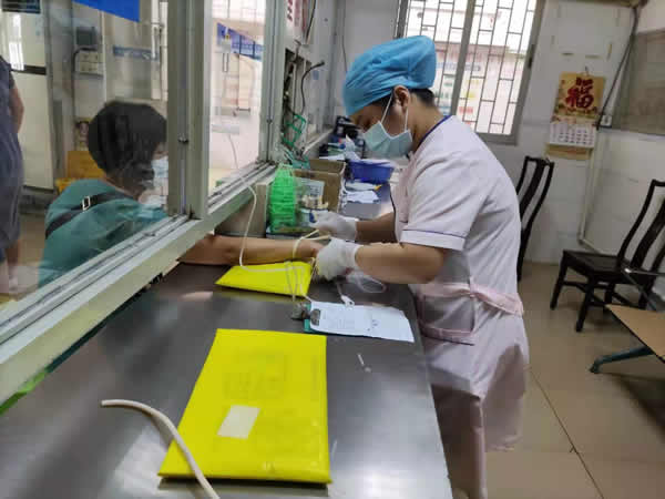 14恩平市君堂镇江洲卫生院护理人员坚守注射室岗位,正在为病人打针